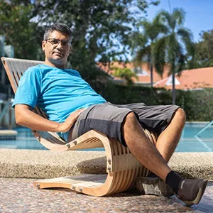 Ajay Verma relaxing in a curved plywood lounge chair he designed and built